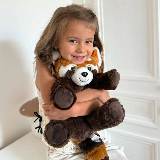 Une petite fille avec sa peluche panda roux